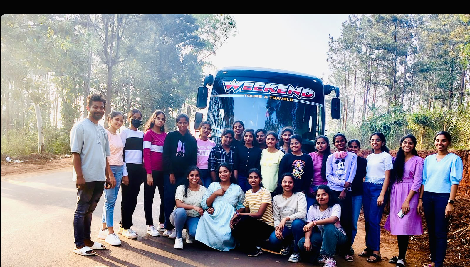 Customer group standing beside a Weekend Tours and Travels bus